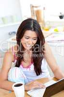 Beautiful Woman using a laptop in the kitchen