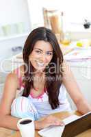 Cute Woman using a laptop in the kitchen