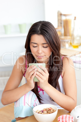 Beautiful woman holding a cup a coffee in the kitchen