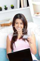 Happy young woman is using a laptop