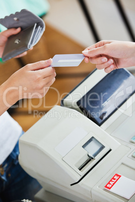 Close-up of a teen woman paying with her credit card