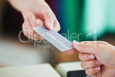 Close-up of a young woman paying with her credit card