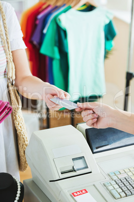 Close-up of a cute woman paying with her credit card