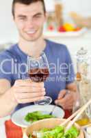Caucasian man eating a healthy salad with some wine