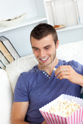 Attractive man is relaxing in the living-room with a remote