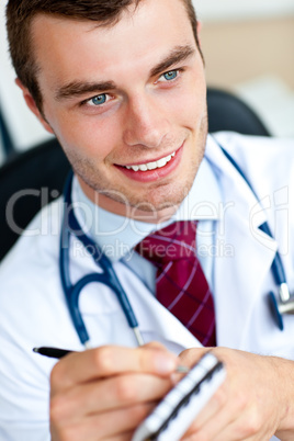 Attractive male doctor writing a perscription