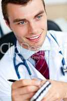 Attractive male doctor writing a perscription