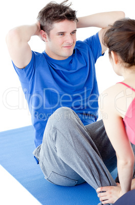 Young man doing fitness exercises with a woman