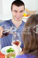 Smiling man eating with woman