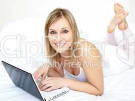 Attractive woman lying with a laptop on sofa