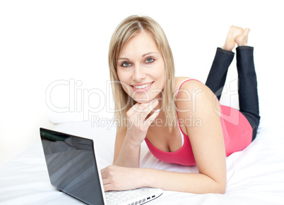 Modern woman lying with a laptop on sofa
