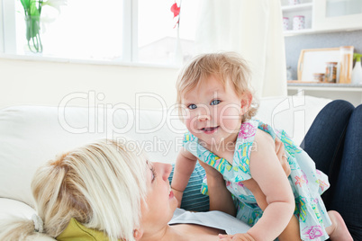 Blond mother playing with her daughter