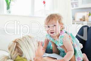 Blond mother playing with her daughter