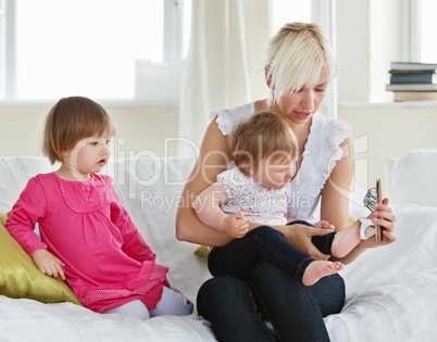 Smiling mother playing with her daughters