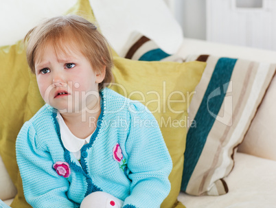 Small girl crying on sofa