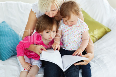 Cute mother reading a book with children