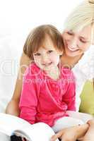 Smiling mother reading a book with children