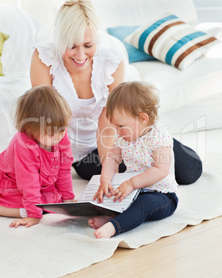 Pretty woman working with her children at laptop