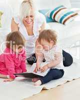Pretty woman working with her children at laptop