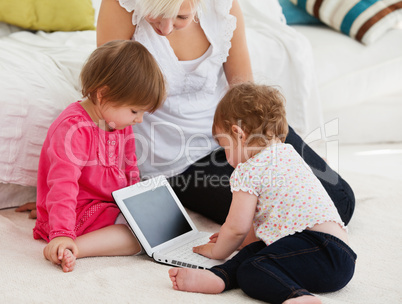 Woman working with her children at laptop