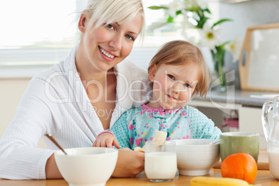 Radiant mother and daughter having breakfast