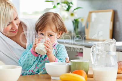 Blond mother and daughter having breakfast