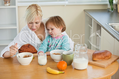 Mother and cute daughter having breakfast