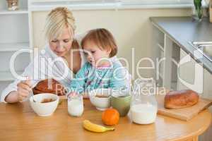 Mother and cute daughter having breakfast