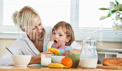 Pretty mother and daughter having breakfast