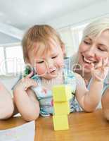 Smiling mother playing with her daughter