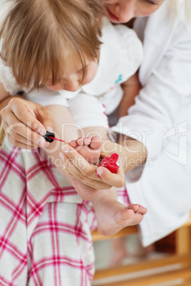 Helping mother making her daughter's nails