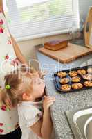 Kind girl standing in kitchen in front of the cookies