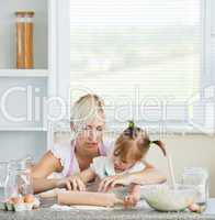 Helping mother and child baking cookies