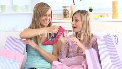 Joyful young woman choosing clothes with her friend in a shop