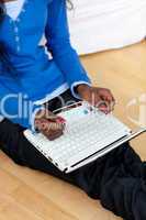 Woman using a laptop sitting on bed