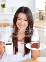 Charming woman holding a cup and a plate