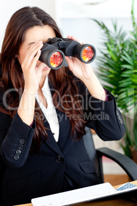 Young businesswoman using binoculars