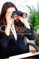 Young businesswoman using binoculars