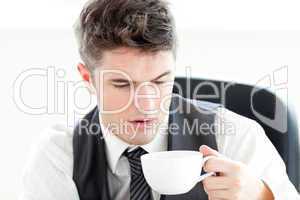 Tired businessman drinking coffee