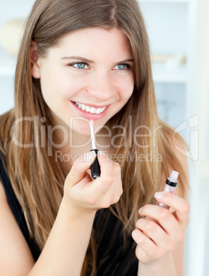 Smiling girl using lipstick
