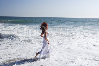 Woman running in to the waves