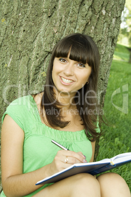 Female in a park with a notebook