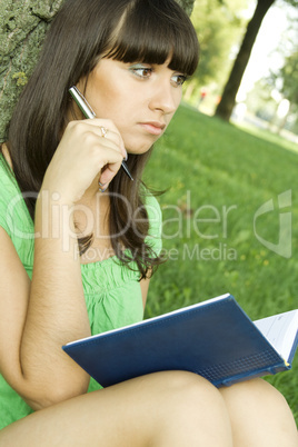 Female in a park with a notebook