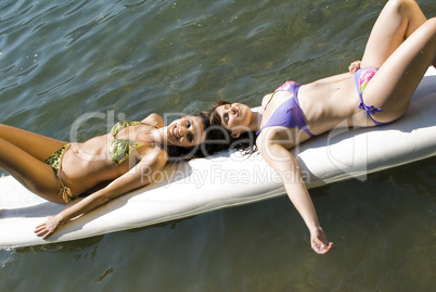 Girls relaxing on surfboard