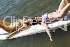 Girls relaxing on surfboard