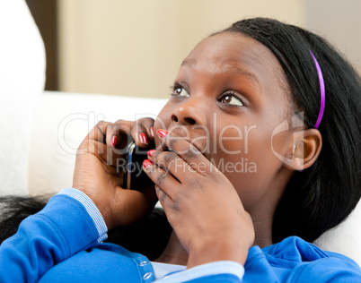 Astonished afro-american teenager talking on phone