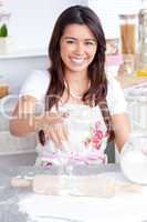 Captivating asian woman baking in her kitchen