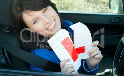 Cheerful young female driver tearing up her L sign