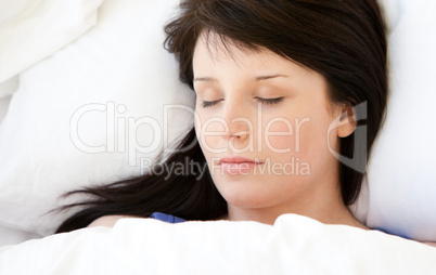 Beautiful young woman lying in a bed sleeping