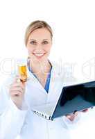 Smiling young doctor holding a laptop and pills